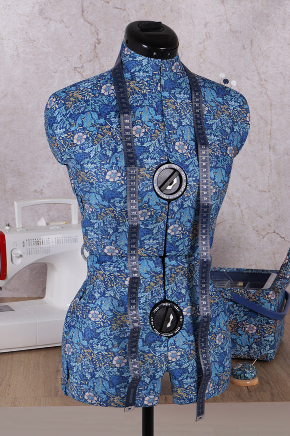 Blue floral dress form with sewing machine in the background